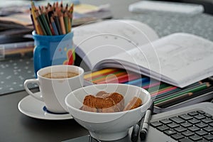 Snacks and coffee at the home office and home schooling process at a kitchen table in coronavirus curfew and quarantine