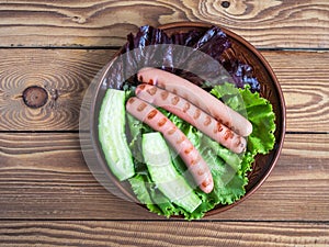 Snacks with lettuce and grilled nipples on a round plate close-up top view