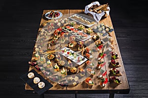 Snacks set. Brushettas, canapes, salads, desserts, tartlets, oysters on wooden table