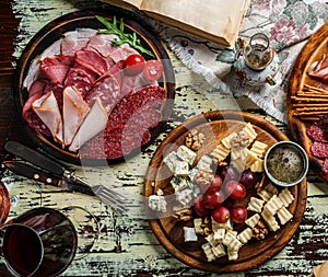 Snacks and Wine appetizer sets, cold meat plates with sausage, ham, salami, prosciutto, bacon and cheese plate with parmesan, blue