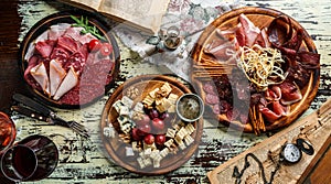 Snacks and Wine appetizer sets, cold meat plates with sausage, ham, salami, prosciutto, bacon and cheese plate with parmesan, blue