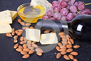 Snacks with wine - bottle, various types of cheeses, figs, nuts, honey, grapes