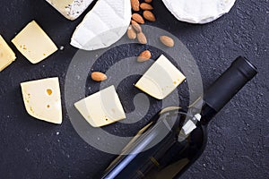 Snacks with wine - bottle, various types of cheeses, figs, nuts, honey, grapes