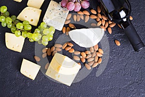 Snacks with wine - bottle, various types of cheeses, figs, nuts, honey, grapes