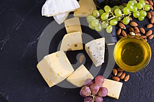 Snacks with wine - bottle, various types of cheeses, figs, nuts, honey, grapes