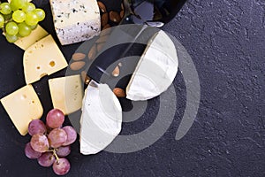 Snacks with wine - bottle, various types of cheeses, figs, nuts, honey, grapes