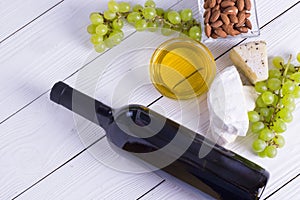 Snacks with wine - bottle, various types of cheeses, figs, nuts, honey, grapes