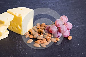 Snacks with wine - various types of cheeses, figs, nuts, honey, grapes