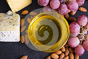 Snacks with wine - various types of cheeses, figs, nuts, honey, grapes