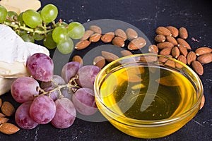 Snacks with wine - various types of cheeses, figs, nuts, honey, grapes