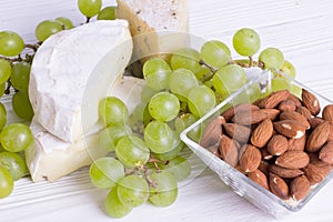 Snacks with wine - various types of cheeses, figs, nuts, honey, grapes