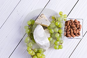 Snacks with wine - various types of cheeses, figs, nuts, honey, grapes