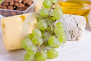 Snacks with wine - various types of cheeses, figs, nuts, honey, grapes