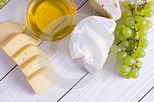 Snacks with wine - various types of cheeses, figs, nuts, honey, grapes