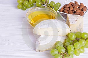 Snacks with wine - various types of cheeses, figs, nuts, honey, grapes