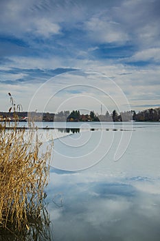 Snagov lake during wintertime frost on the surface.Cold temperature.Bucharest Romania.Clouds and blue sky