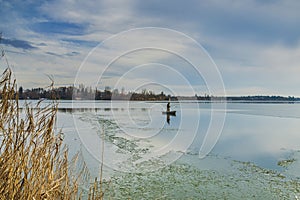 Snagov lake during wintertime frost on the surface.Cold temperature.Bucharest Romania.Clouds and sky