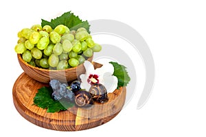 A snail and a bunch of grapes with hibiscus color on a wooden board. White background