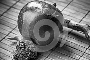 Snail sitting on apple and tree trunk and go to green broccoli, wooden bamboo backdrop, close-up animal background