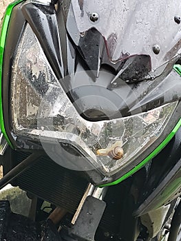 Snail sitting on beautiful green Kawasaki motorcycle