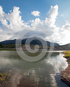 Snake River and Central Rocky Mountains under cumulus cloud sky in Alpine Wyoming