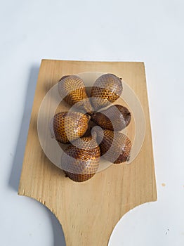 Snakefruit with dark brown skin, the fruit is under the tree