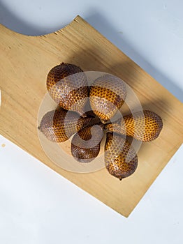 Snakefruit with dark brown skin, the fruit is under the tree