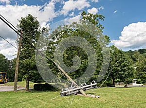 Snapped and downed power post and line after storm