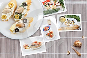 Snapshots of various sandwiches with seafood arranged on rustic wooden background with plates with food and seashells