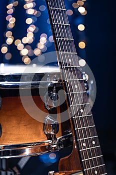 Snare drum and guitar on a blurry dark background with bokeh.