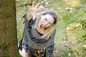 Snarling angry woman clawing at the camera in a forest