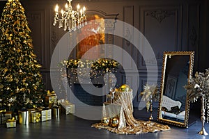 Snazzy christmas interior in living room, golden decorations , lights, christmas tree and heap of gifts, golden mirror and