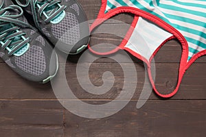 Sneakers and activewear are on the wooden background