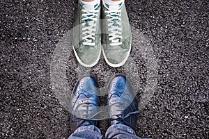 Sneakers and business shoes face to face on asphalt, work life balance concept