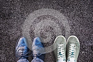 Sneakers and business shoes side by side on asphalt, work life balance