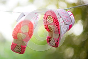 sneakers dried on a rope in the summer sunny garden
