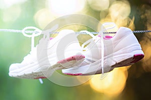 sneakers dried on a rope in the summer sunny garden