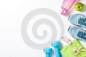 Sneakers, dumbbells, green apple and bottle of water isolated on white background.