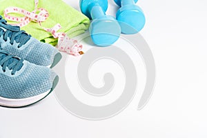 Sneakers, dumbbells, green apple and bottle of water isolated on white background.