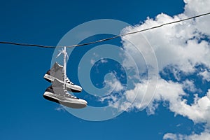 Zapatillas colgante sobre el eléctrico conductores 