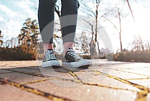Sneakers on the legs of a woman walking in the park