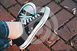 Sneakers on the legs of a woman walking in the park