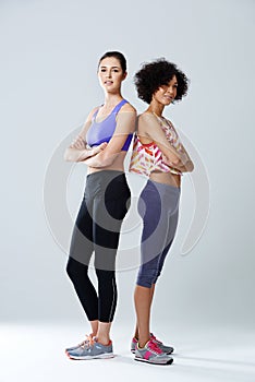 Sneakers before stilletos. two woman standing in a studio wearing sports clothing.