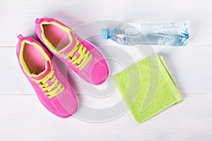 Sneakers with a towel and a bottle of water for sporting activities, set on a beautiful background