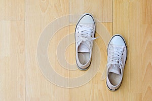 Sneakers white top view sports shoes close-up on a wooden background top view
