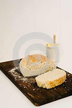 Sneaky Sourdough, homemade, on a breadboard with butter pot