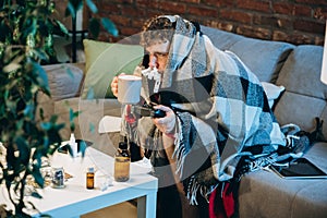 Cropped portrait of young sick boy having cold and flu, allergy. Running nose, sneezing. Home isolation