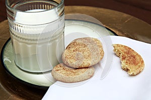 Snickerdoodle cookies on golden plate with glass of milk