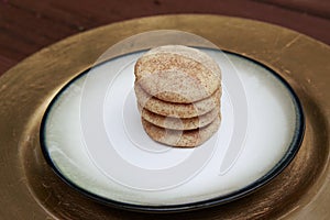 Snickerdoodle cookies stacked on a golden plate