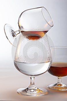 A snifter of brandy being warmed above a glass of hot water